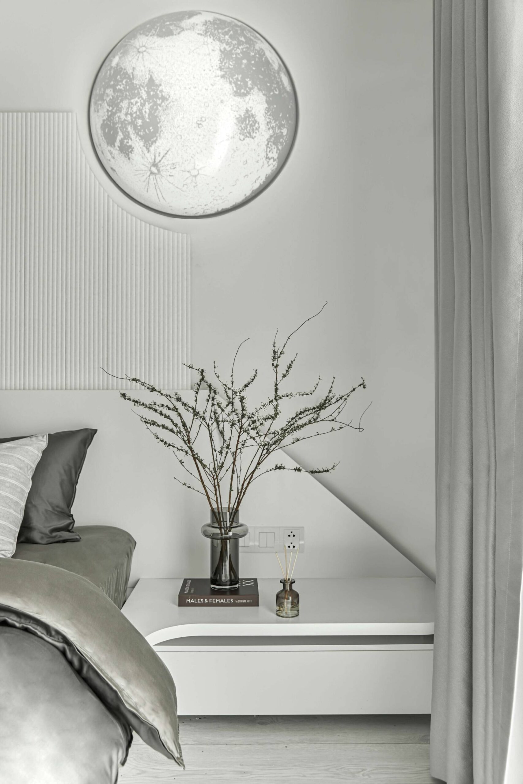 Above the headboard, an impressive Moon lamp showing the apartment’s theme.