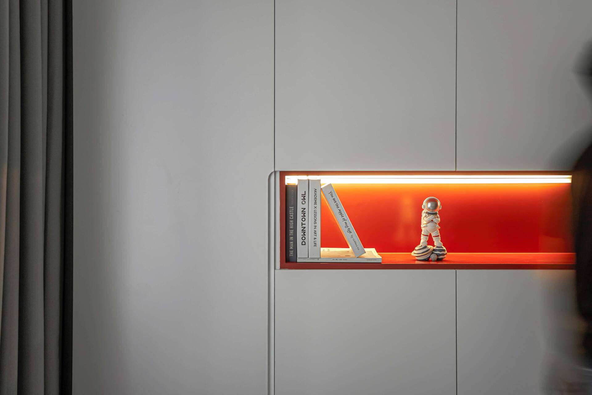In the opposite of the bed a drawer is painted in prominent orange