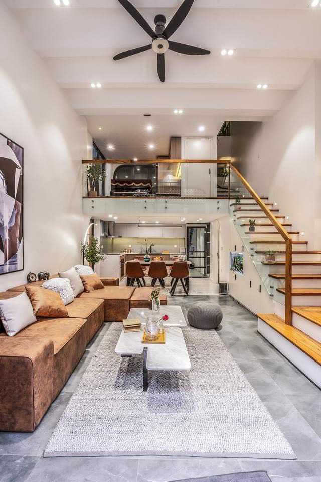 Furniture is designed in a modern style. The ground floor includes a living room, a kitchen, dining area, and a bathroom which are all designed in the same open space. A big caramel sofa becomes a warm accent in the living room. This sofa set can be used as a bed to rest and relax when necessary.