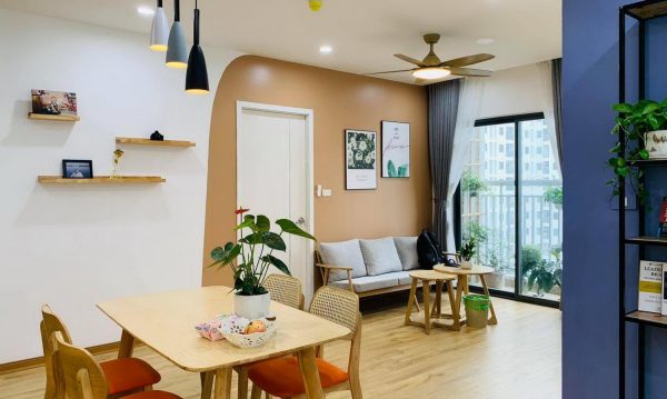 The living room connects with the dining table and receives natural light from the large glass doors.