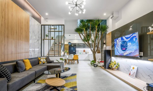 The living room and kitchen are separated by the void space and floor to ceiling cabinet.