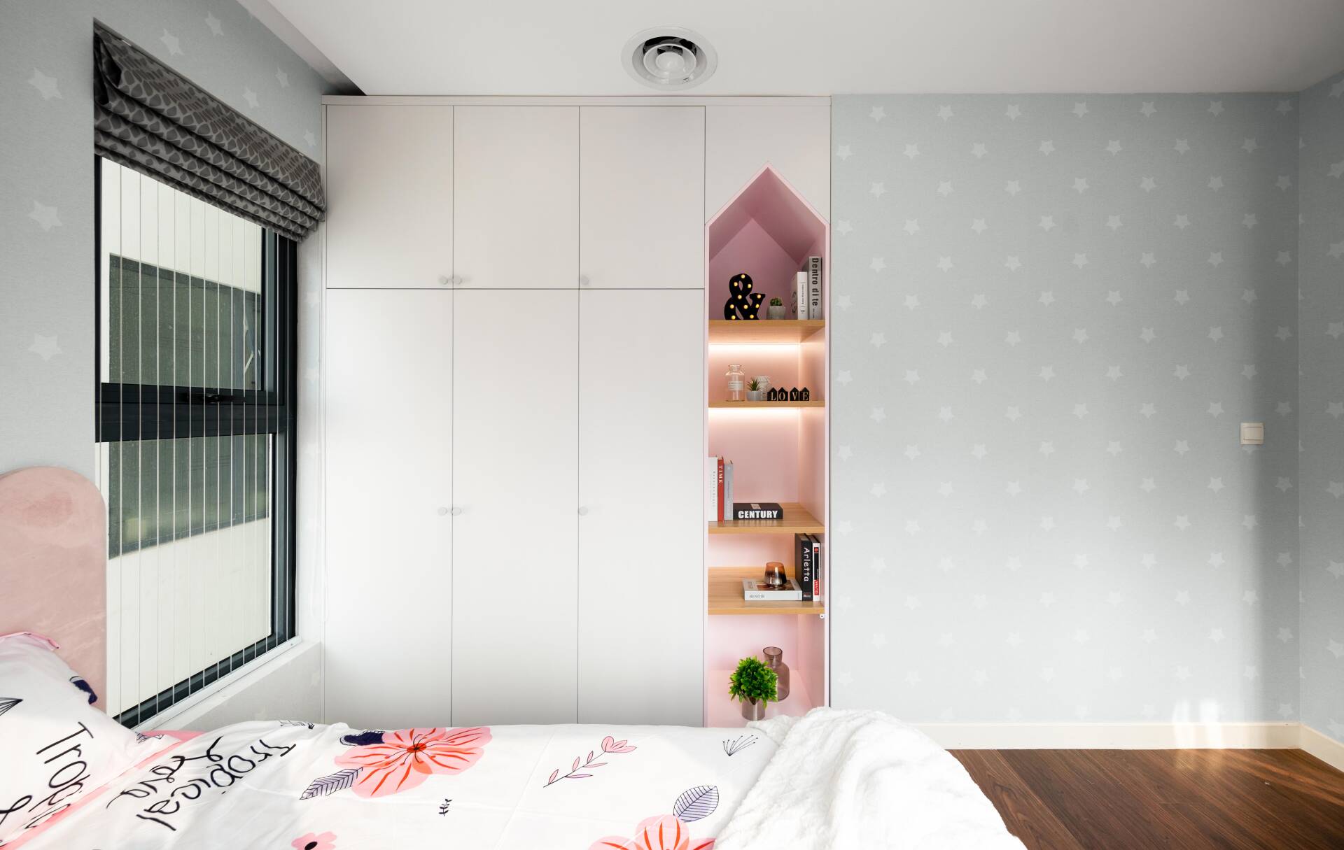 The recessed wardrobe combines with bookshelves to help optimize the area.