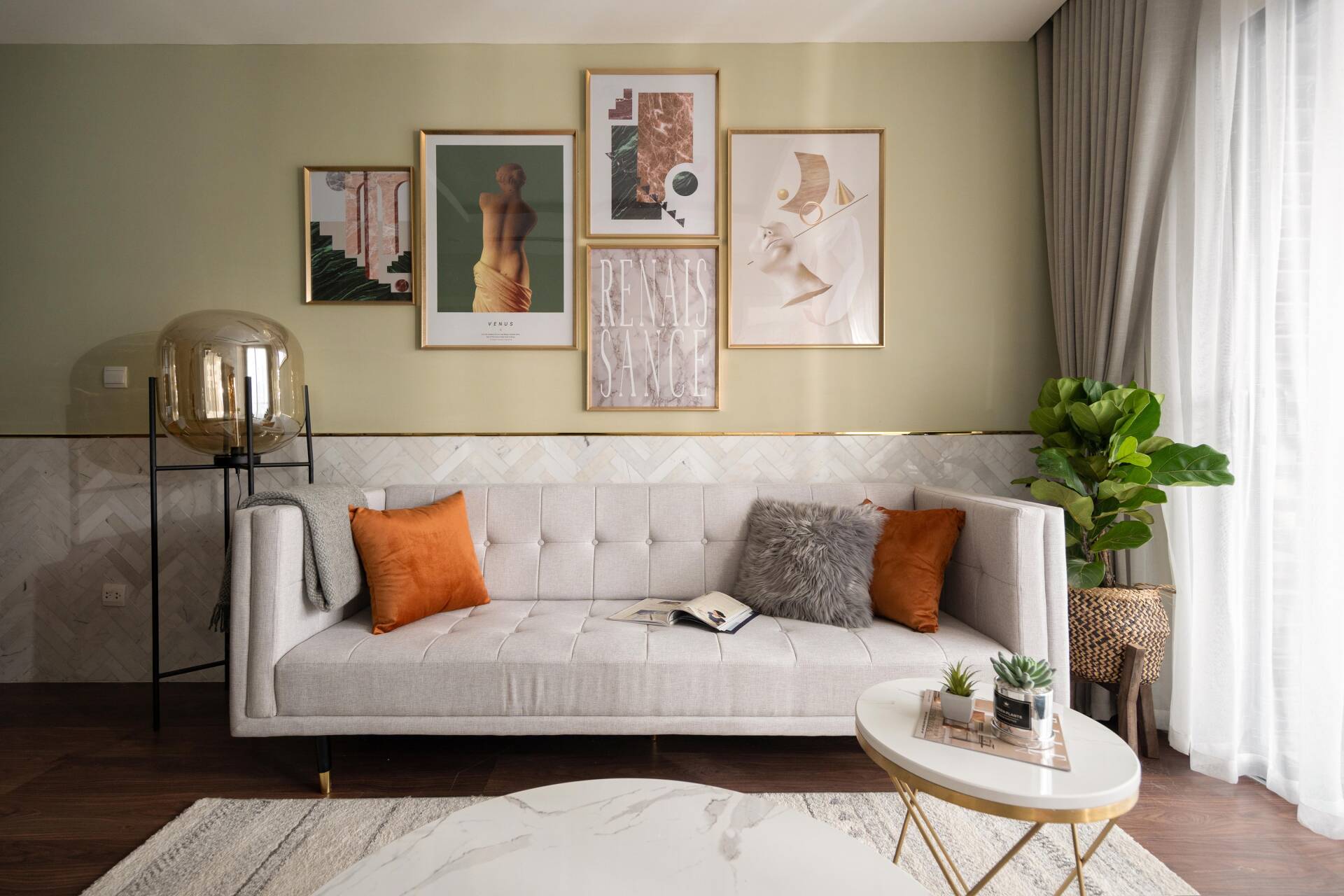 The cream fabric sofa is adorned with small orange and gray pillows that are very harmonious.