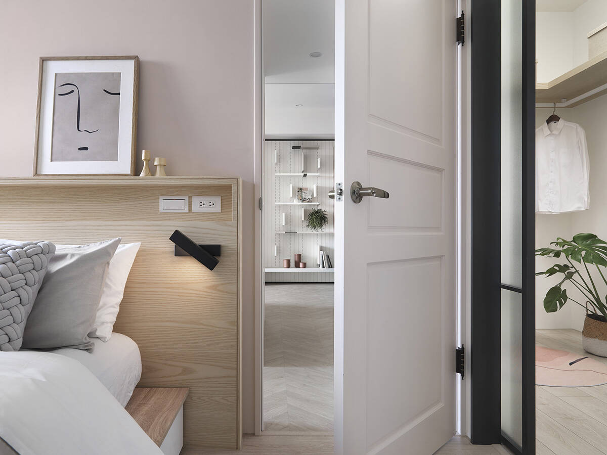 The dressing room is right next to the bedroom and is separated to it by a black sliding glass door frame.