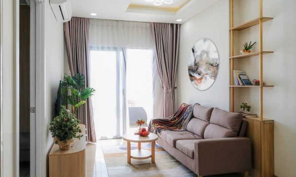 The living room is open and airy, receiving natural sunlight from large windows. The living room balcony captures the city view.