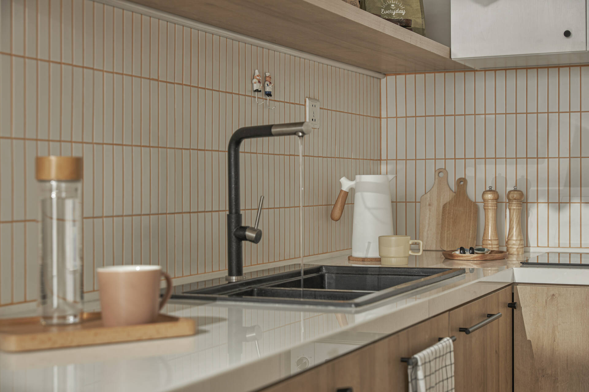 In order for the kitchen to have a ton-sur-ton color scheme with the overall apartment, the grout among tiles is also designed in eye-catching orange.
