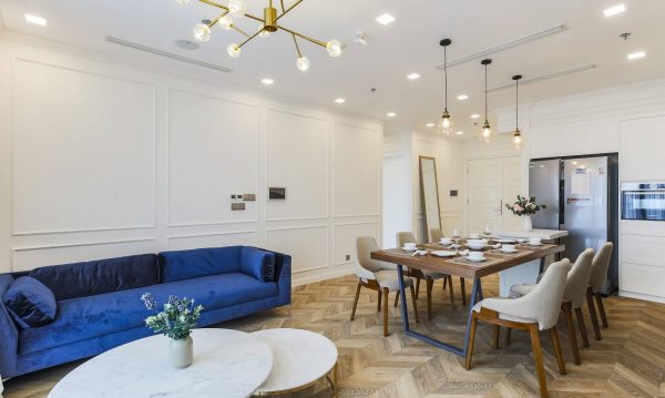The velvet blue sofa is the highlight of the room with an elegant design.