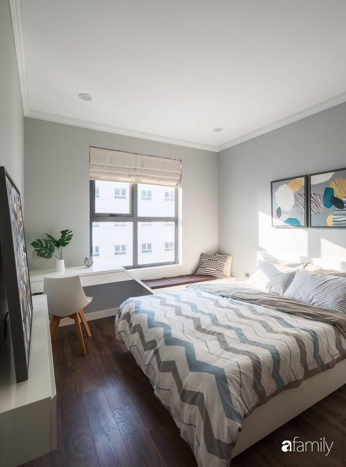 Another bedroom with a cool pastel tone. Natural light fills the room through large glass windows.