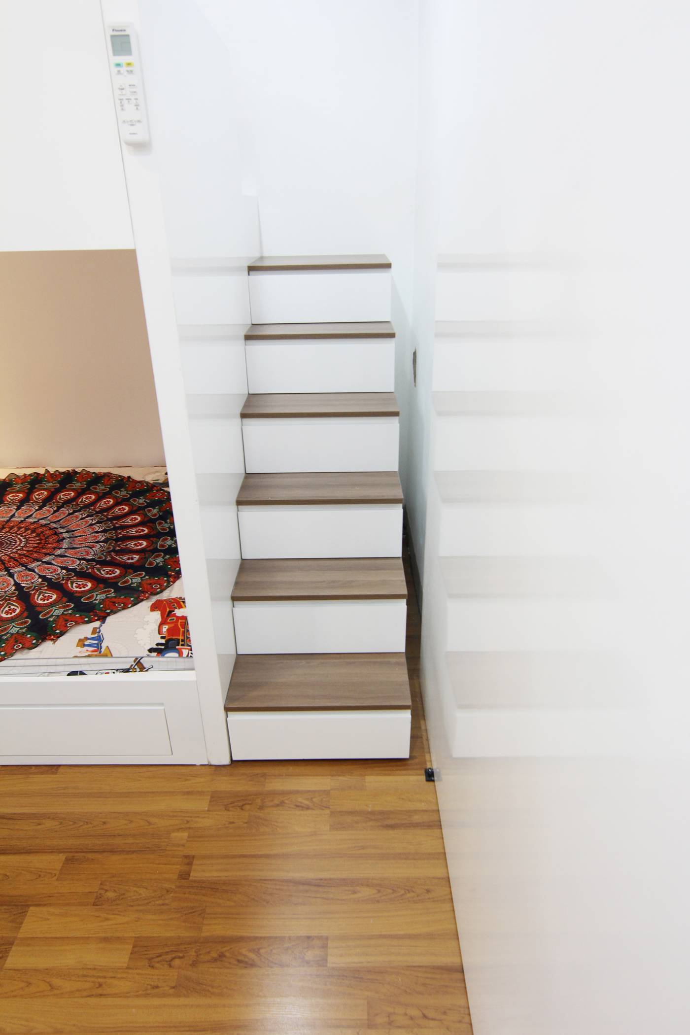 Owners can move up to the area above the bed by this small staircase.