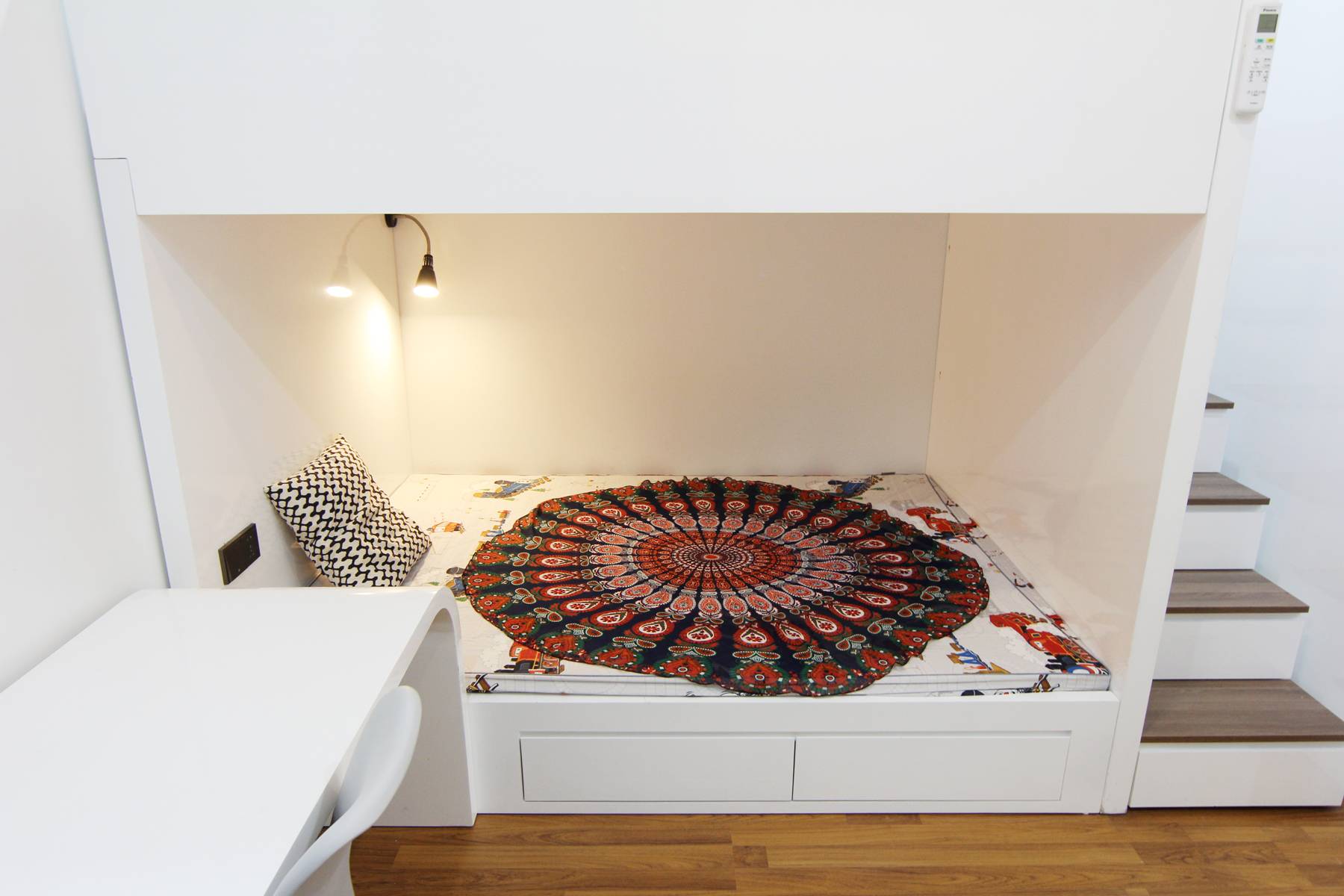 The blanket in this bedroom looks unique and colorful, matching the user's personality.