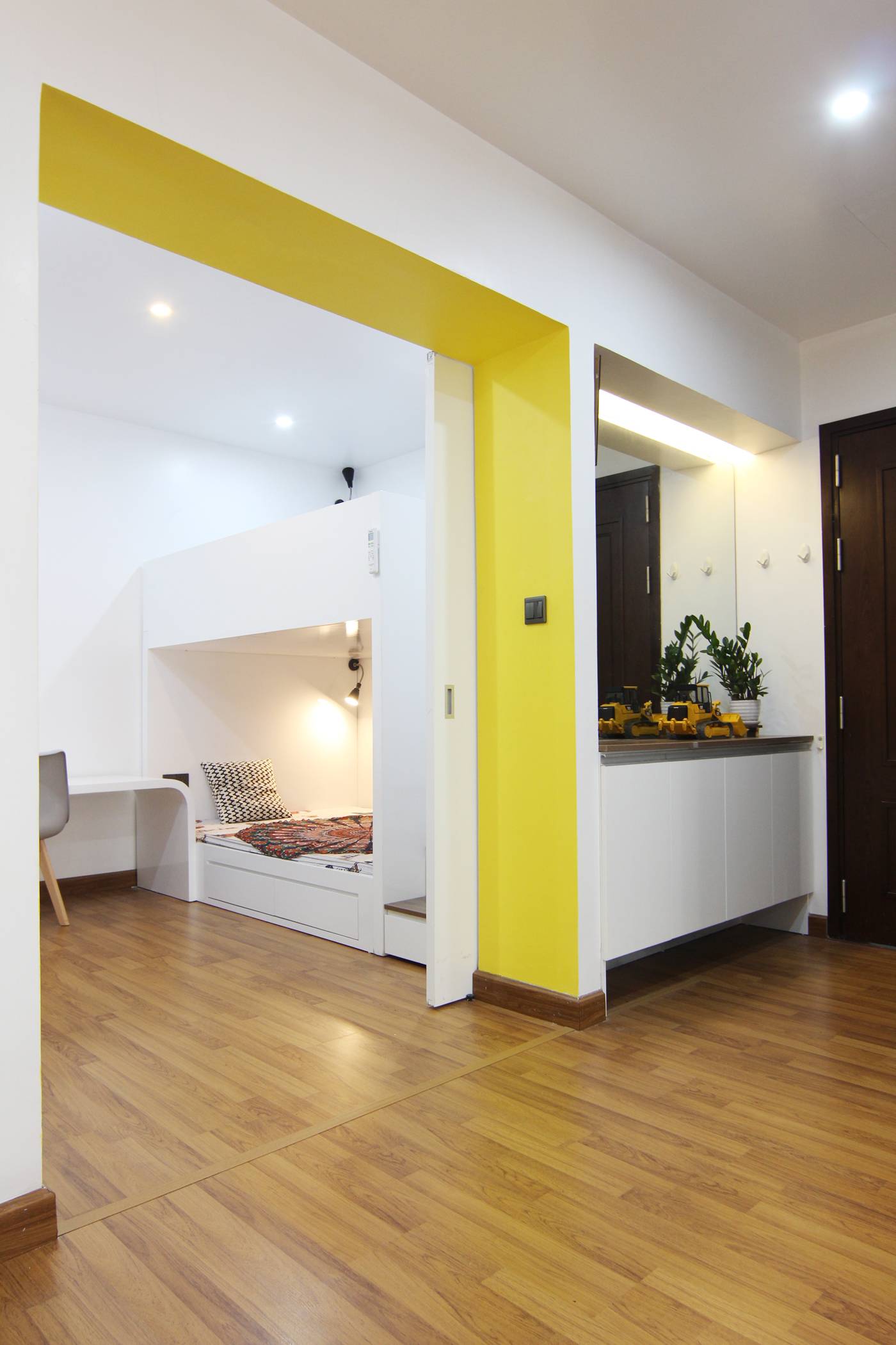 A partition wall is removed to create a connection between sleeping space and common area.