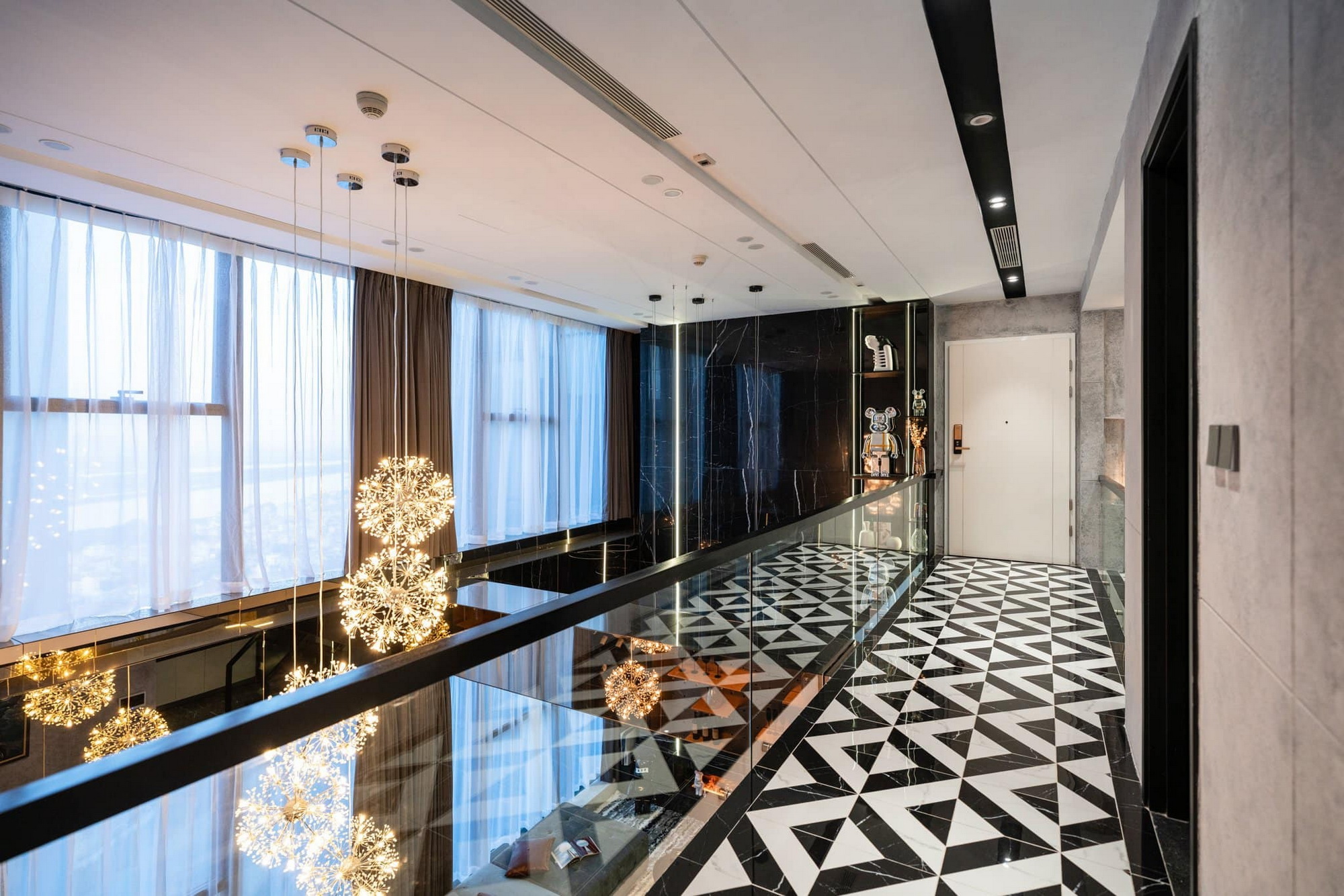 The second-floor corridor is covered with black and white enamel motifs that complement the apartment's overall color scheme while distinguishing it from the first floor. 